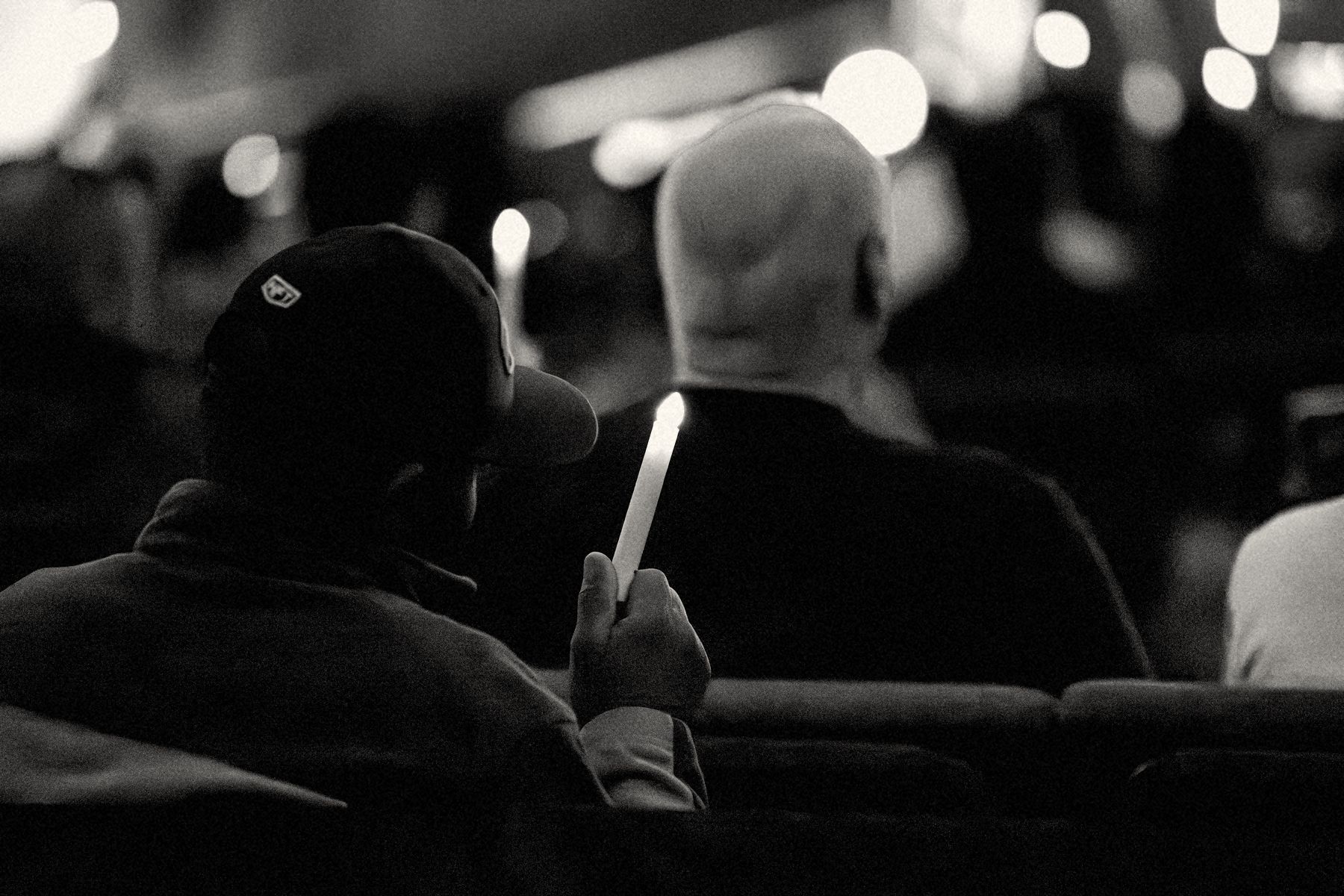 A man holds a lit candle during a Christmas candlelight service at Real Life